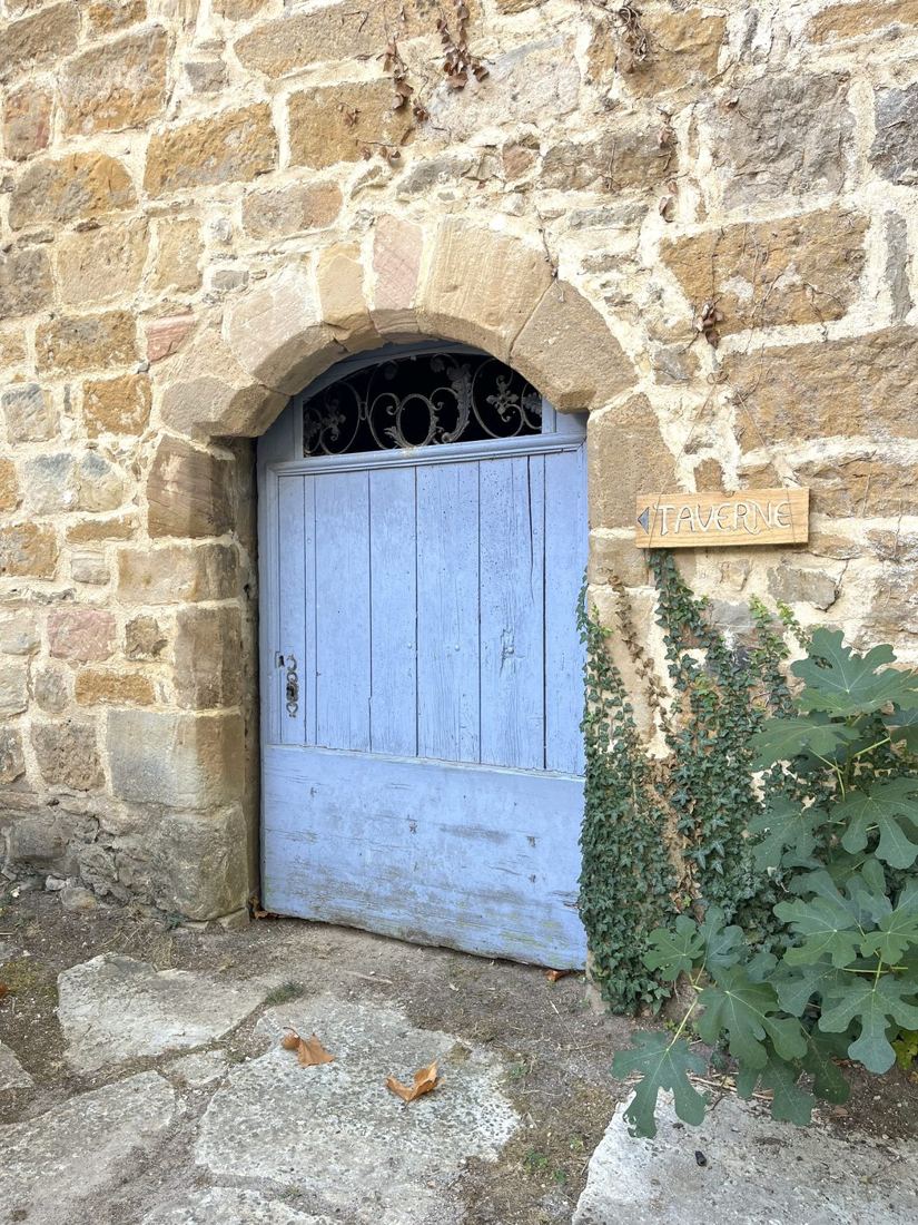 La porte bleue du caveau de la Taverne, sous son arc de pierre