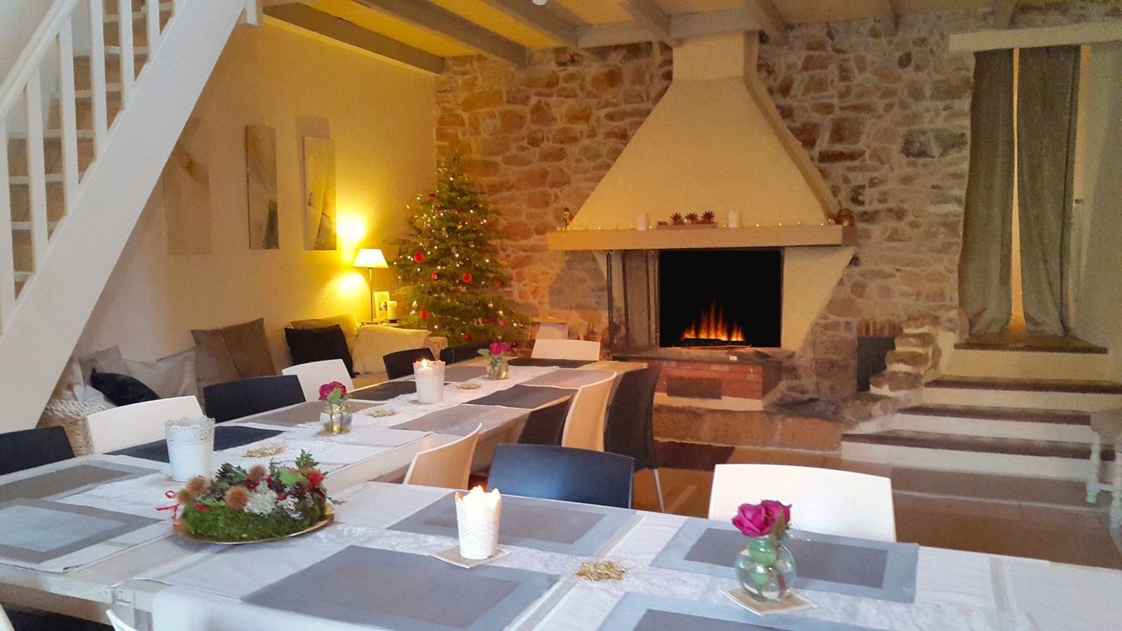 La salle à manger un soir d'hiver : sapin de Noël, bougies et feu de cheminée