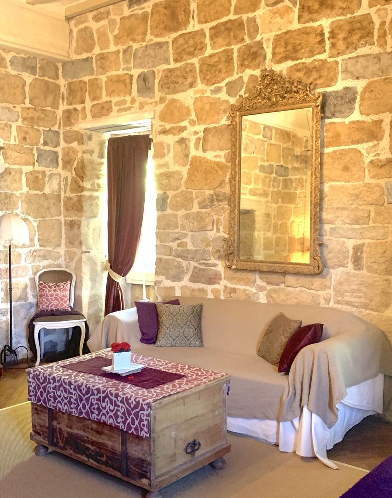 Le coin salon de la chambre de l'Évêque, miroir doré et pierre apparente